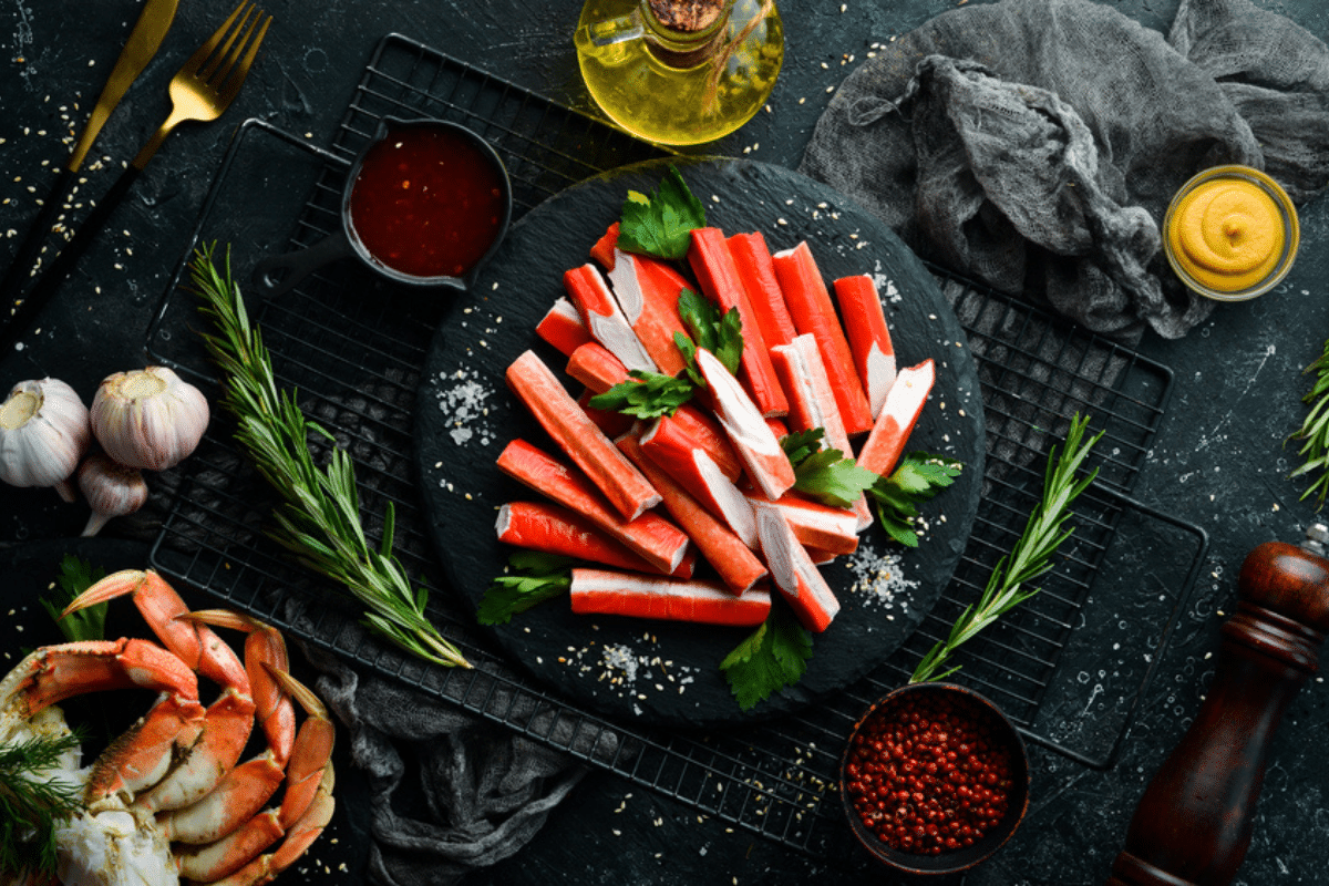 surimi na czarnym talerzu obok zdrowych warzyw